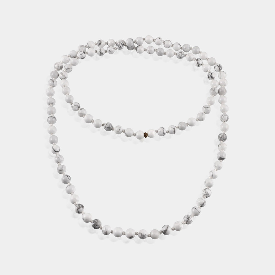 Close-up of Howlite Gemstone beads, revealing the intricate details and smooth texture for a tactile meditation experience.