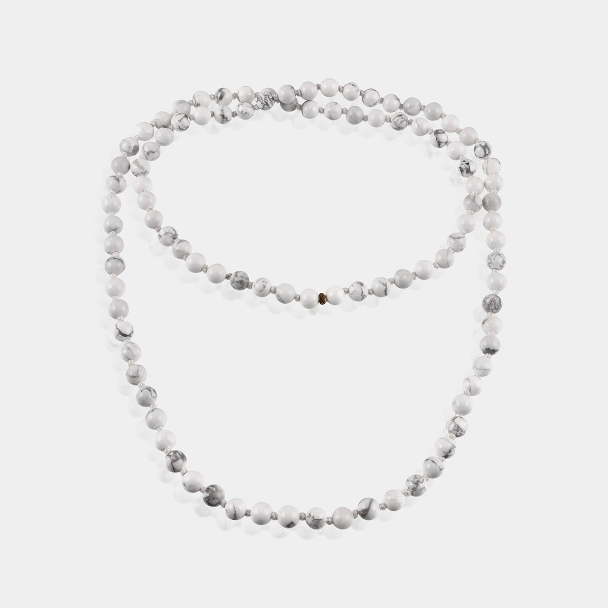 Close-up of Howlite Gemstone beads, revealing the intricate details and smooth texture for a tactile meditation experience.